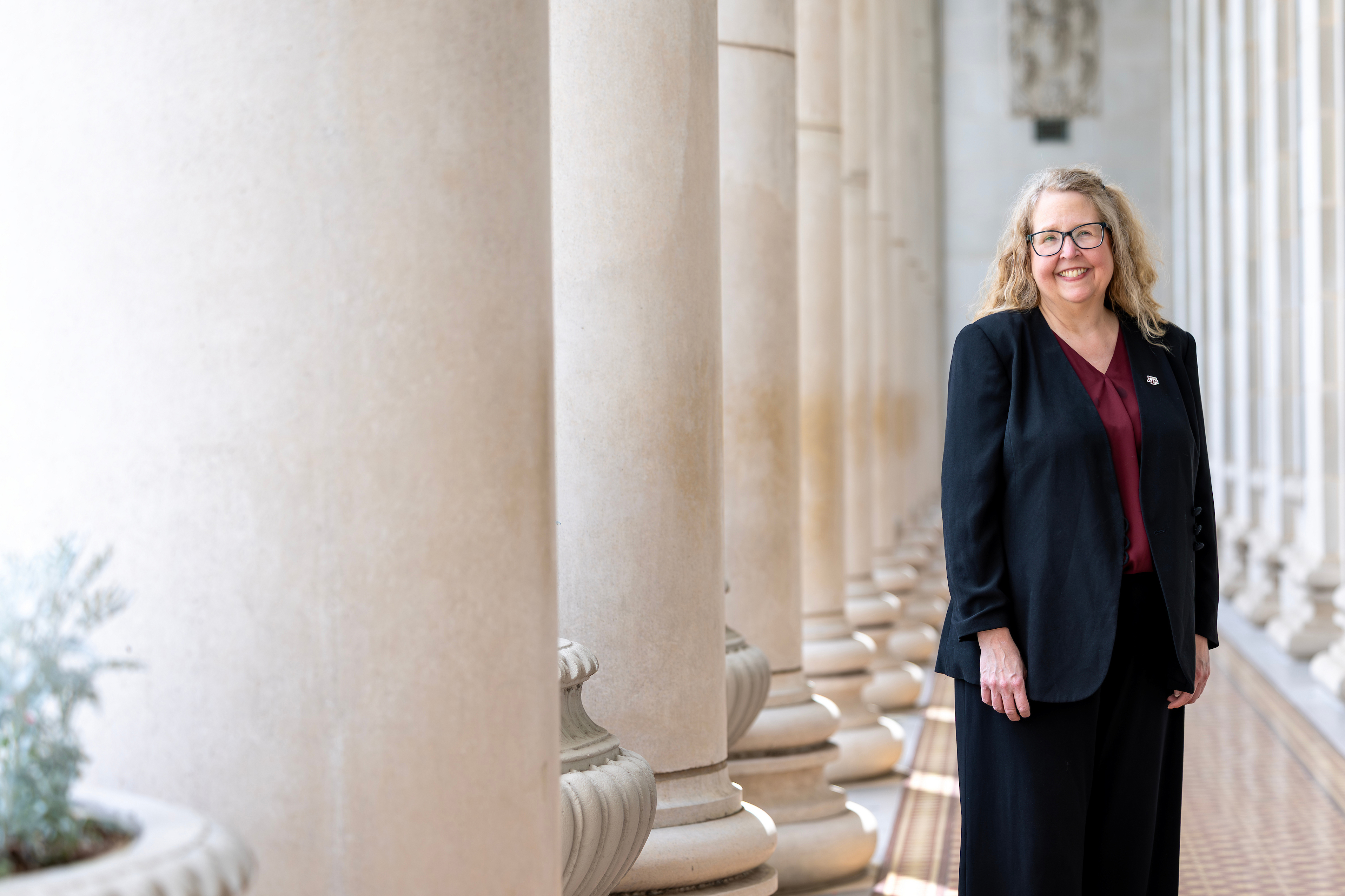 Angela Wilson posing by the pillars of the Jack K. Williams Administration Bulding